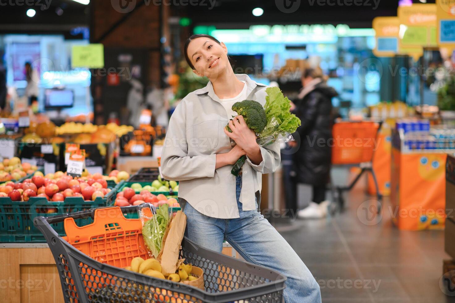 jong vrouw buying groenten Bij kruidenier markt foto