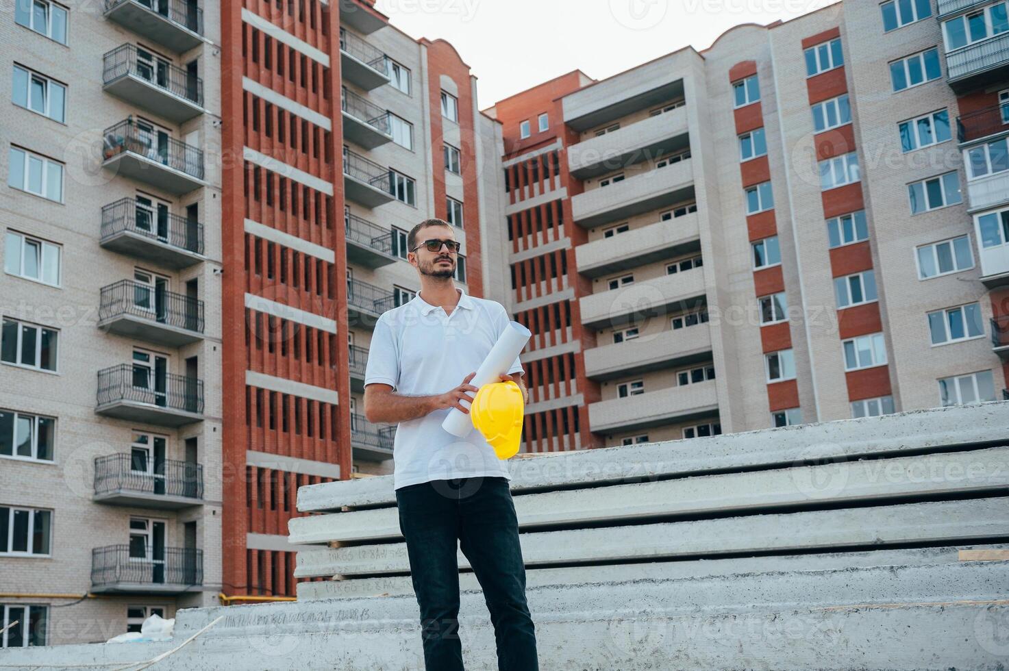 portret van een architect bouwer aan het studeren lay-out plan van de kamers, echt civiel ingenieur werken met documenten Aan bouw plaats. foto