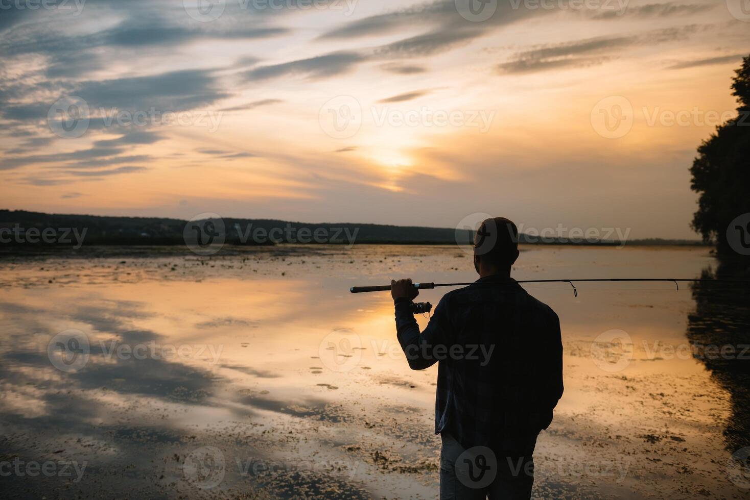 visser Mens visvangst met spinnen hengel Aan een rivier- bank Bij nevelig mistig zonsopkomst. visser met draaien. spinnen concept. foto