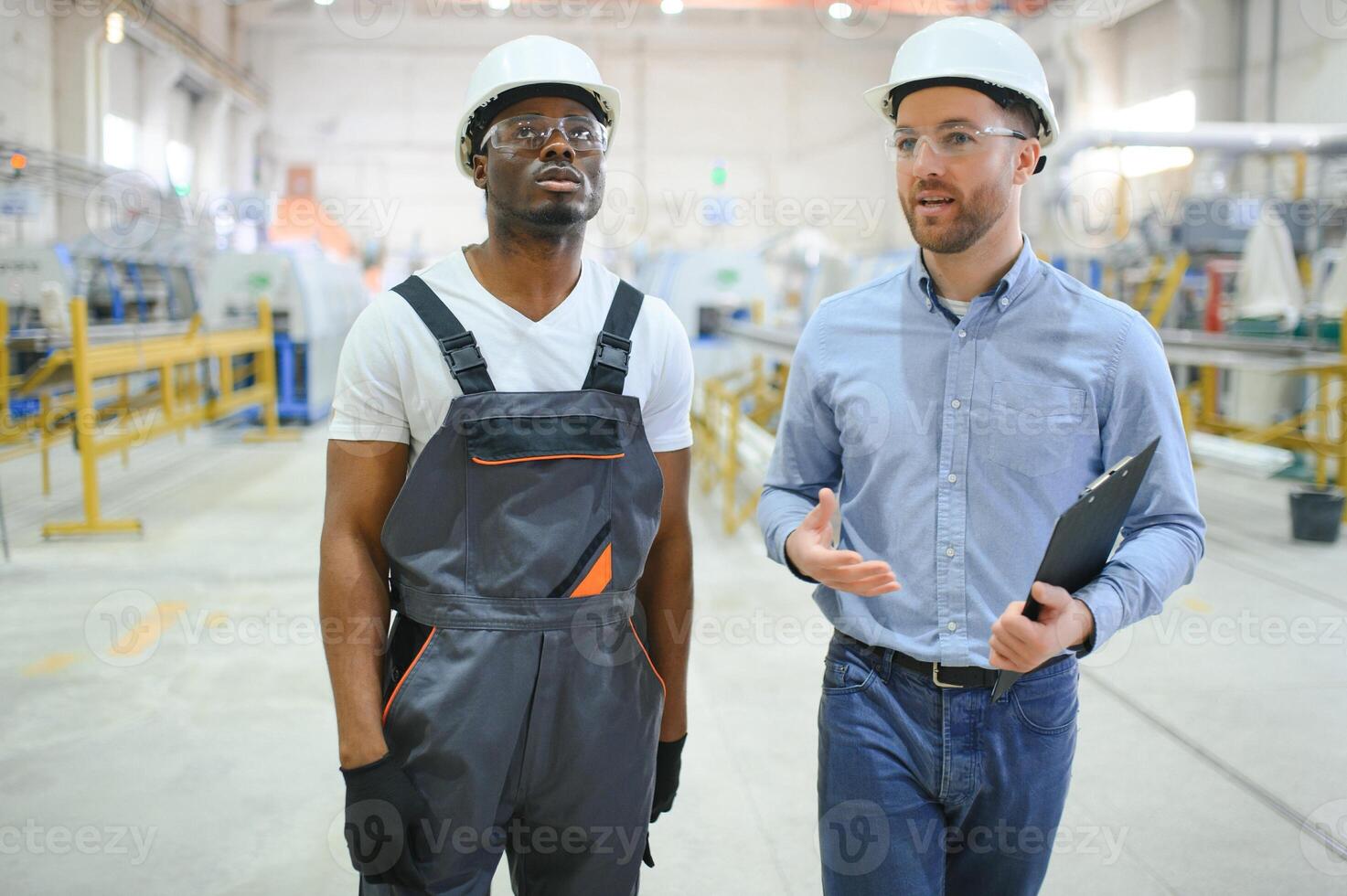 twee arbeiders in productie fabriek net zo team bespreken, industrieel tafereel in achtergrond foto