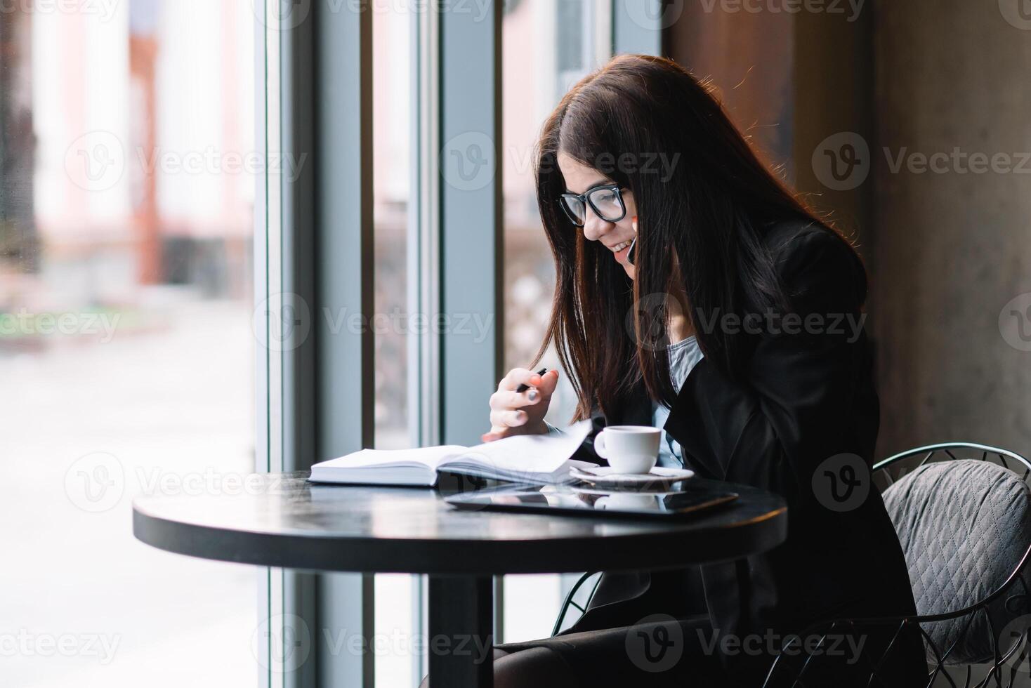 jong zakenvrouw pratend Aan de telefoon in koffie winkel. foto