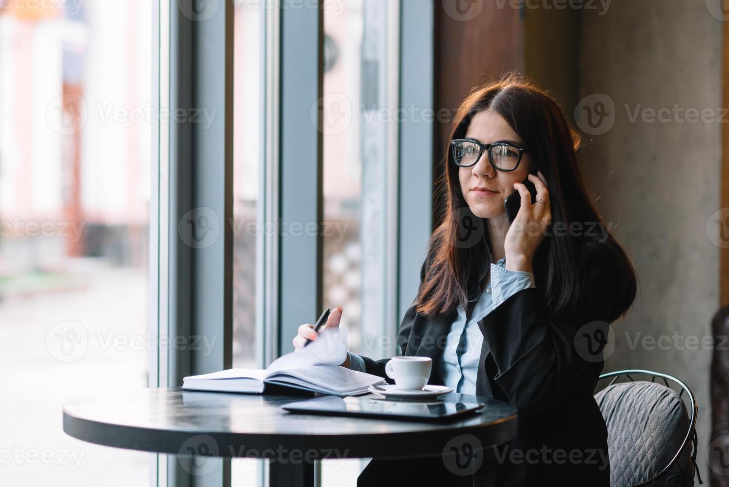 jong zakenvrouw pratend Aan de telefoon in koffie winkel. foto