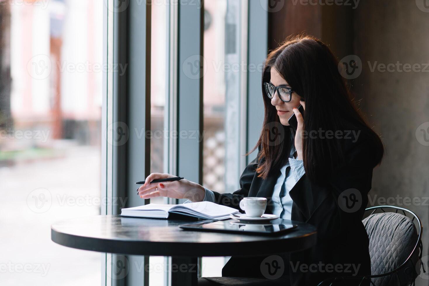 jong zakenvrouw pratend Aan de telefoon in koffie winkel. foto