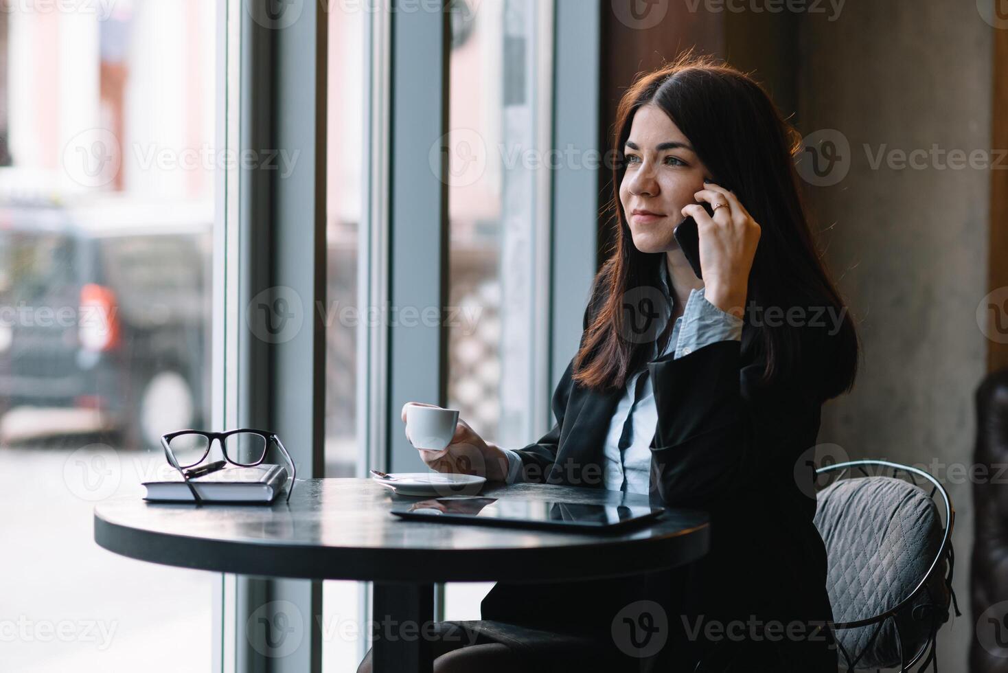 jong zakenvrouw pratend Aan de telefoon in koffie winkel. foto