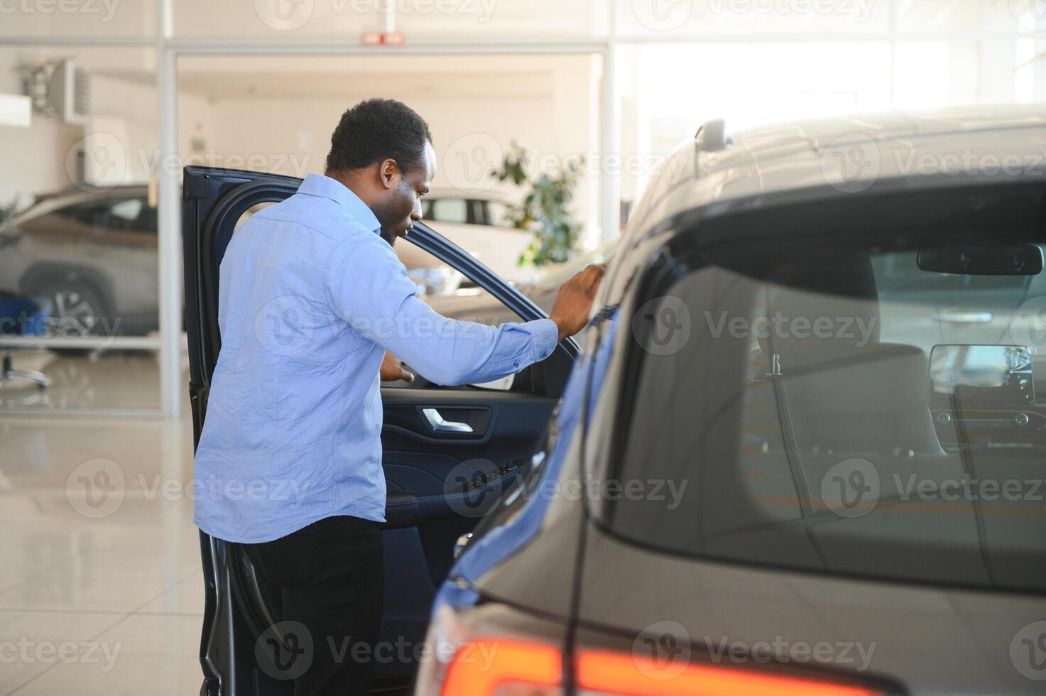 jong Afro-Amerikaans Mens kwam naar zien auto's in handel of auto's toonzaal foto