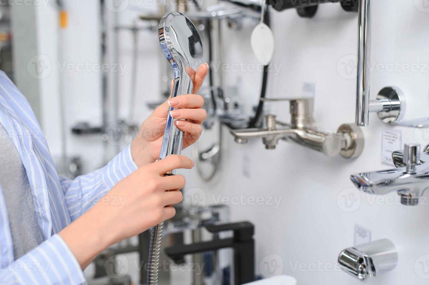 vrouw kiezen een douche hoofd in een hardware op te slaan foto