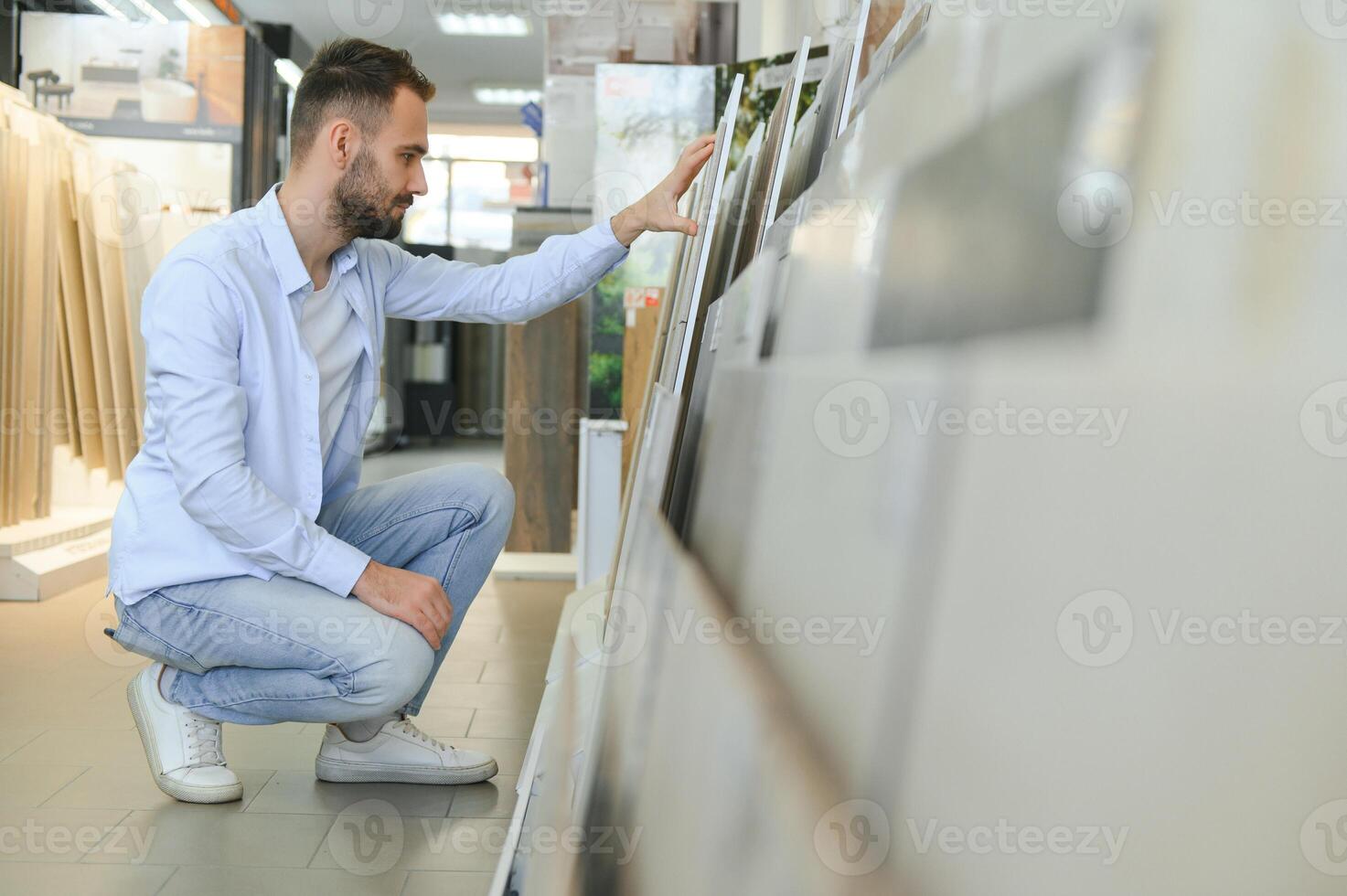 Mens kiezen keramisch tegels en gereedschap voor zijn huis badkamer foto