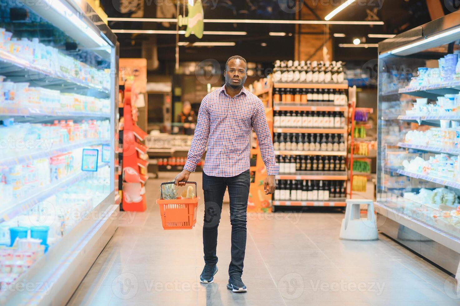 Afrikaanse Mens boodschappen doen Bij supermarkt. knap vent Holding boodschappen doen mand foto
