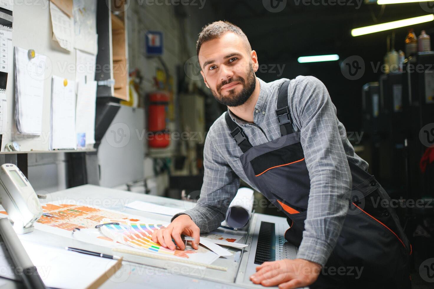 Mens werken in het drukken huis met papier en verven foto