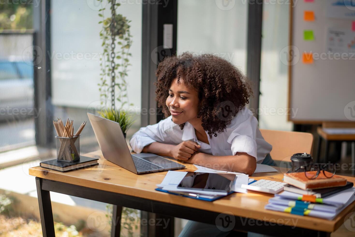 een vrouw kantoor arbeider is betalen aandacht naar de bevindingen Aan de laptop scherm. gedurende werk, online ontmoeting, staren Bij laptop scherm glimlach genieten mooi zo nieuws foto