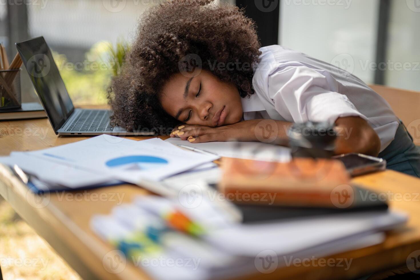 de vrouw werknemer viel in slaap Aan de bureau. uitgeput overbelasten zwart zakenvrouw vallend in slaap Aan bureaublad. moe van werk foto