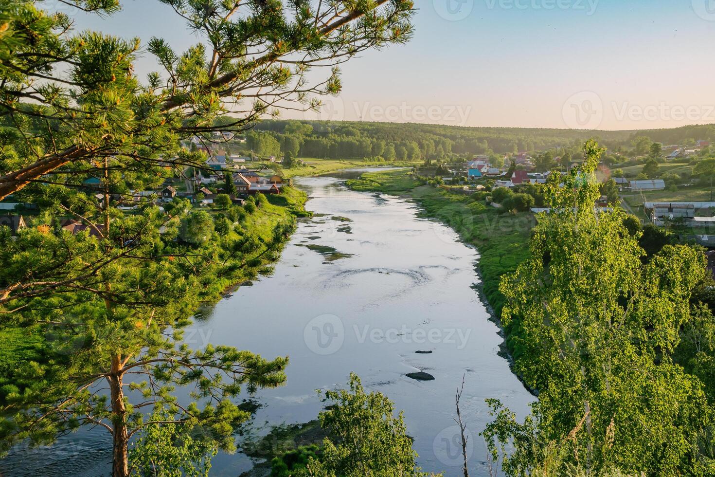 zonnig dorp rivier- en geschorst brug foto