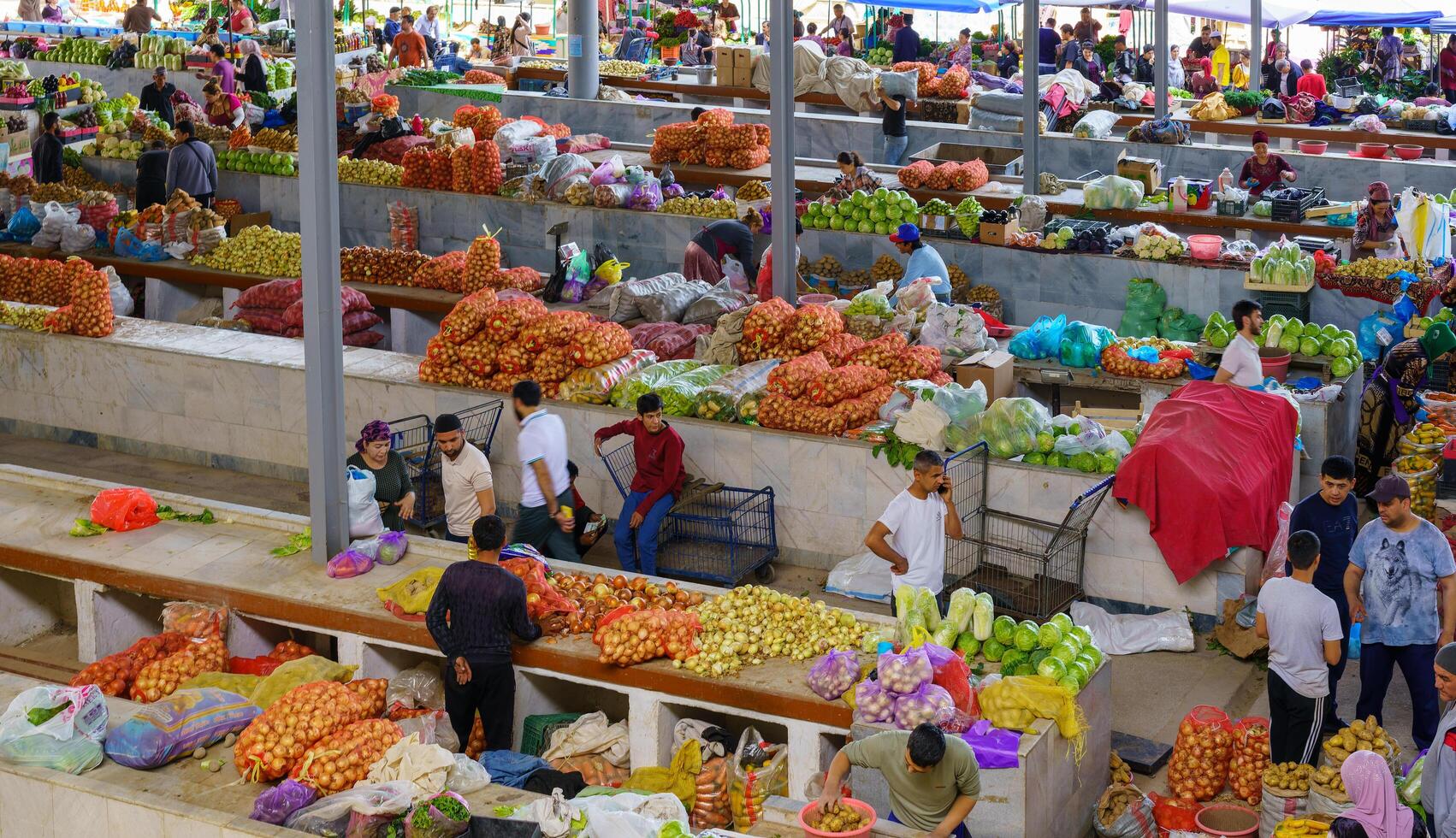 samarkand, Oezbekistan - april 27, 2023 top visie van rijen van fruit en groente kraampjes en verkoper in een oosters bazaar in centraal Azië. foto