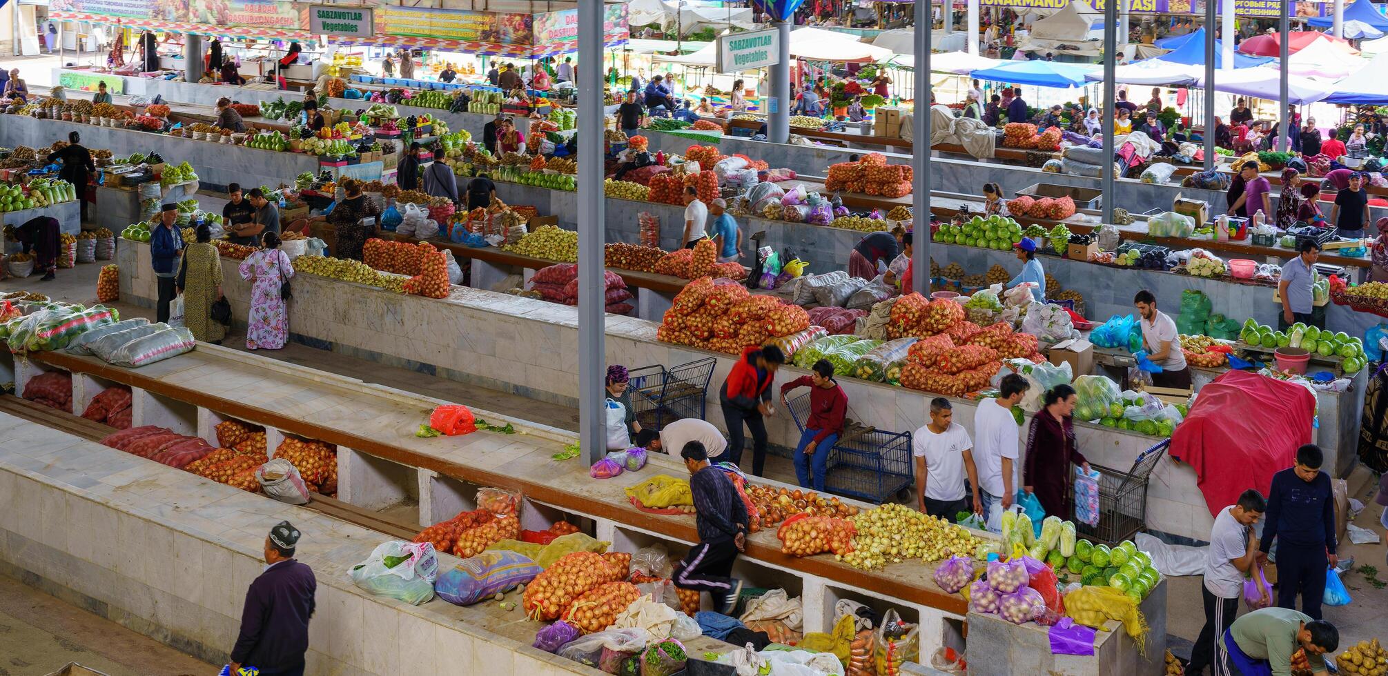 samarkand, Oezbekistan - april 27, 2023 top visie van rijen van fruit en groente kraampjes en verkoper in een oosters bazaar in centraal Azië. foto