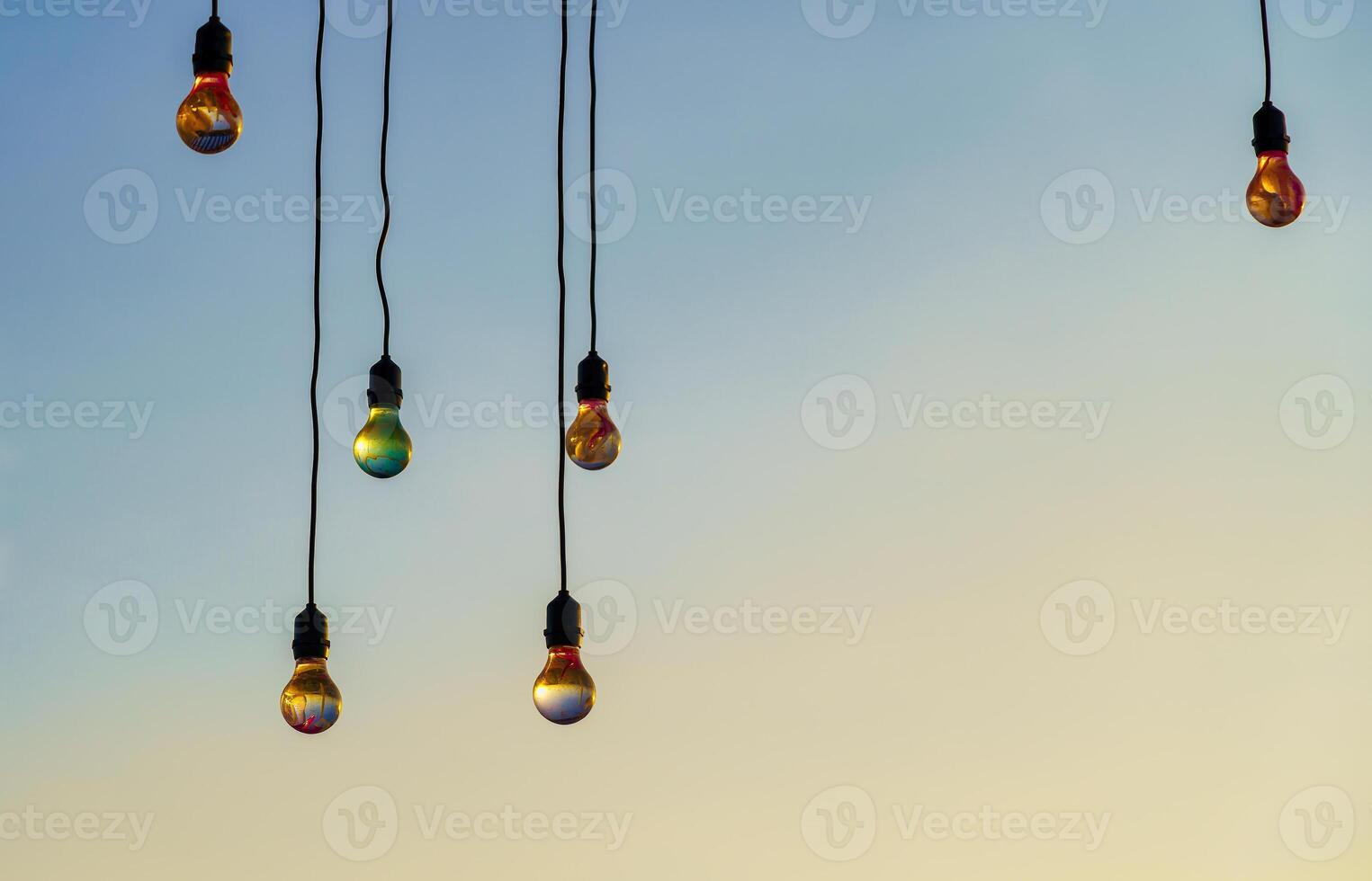 feestelijk hangende slingers met licht bollen tegen de achtergrond van een schemering lucht. foto