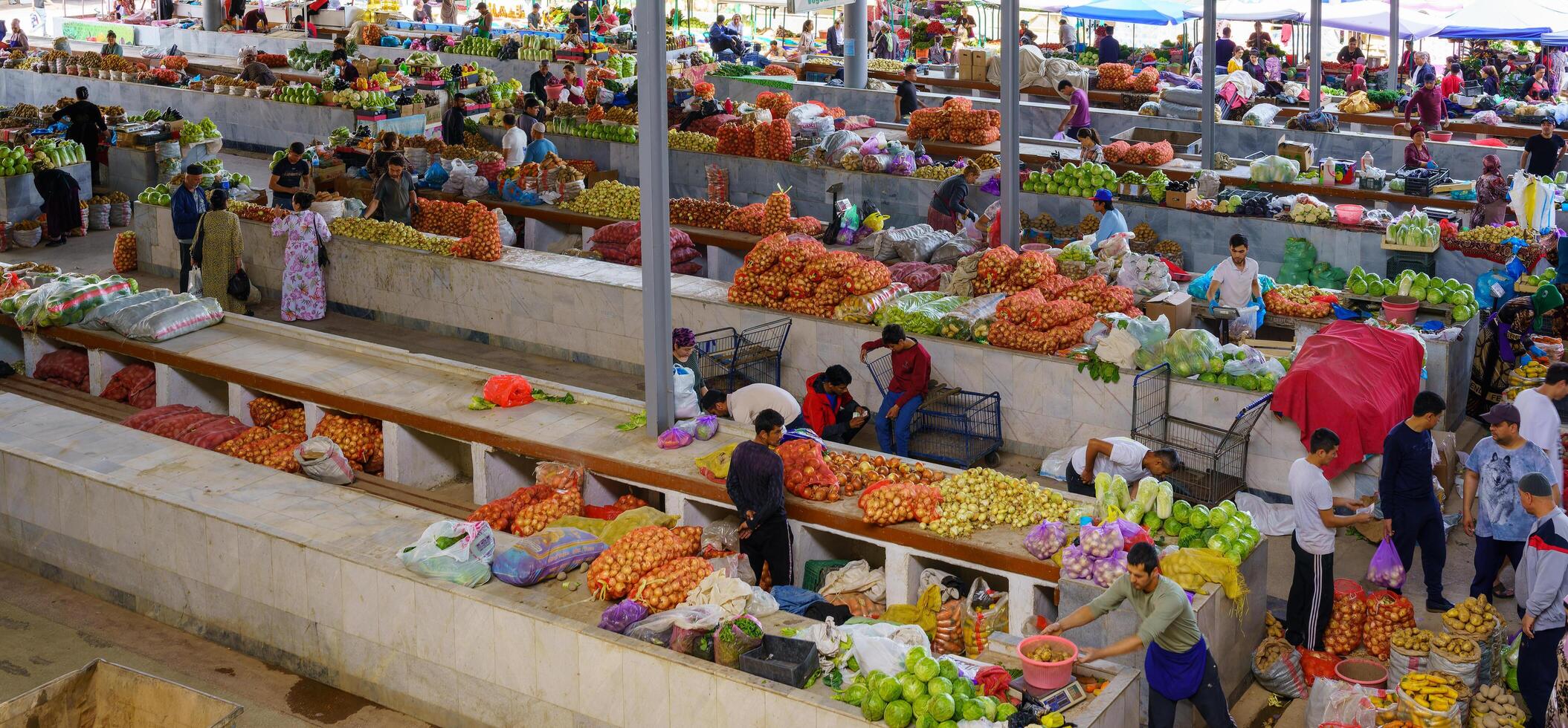 samarkand, Oezbekistan - april 27, 2023 top visie van rijen van fruit en groente kraampjes en verkoper in een oosters bazaar in centraal Azië. foto