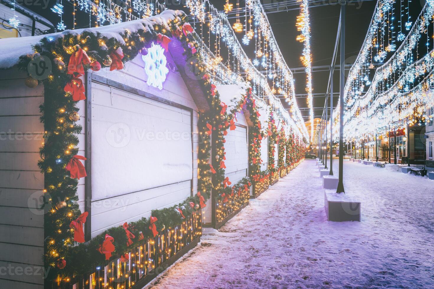 Kerstmis of nieuw jaar markt in een Europa met huizen versierd met speelgoed- ballen en slingers Bij nacht. wijnoogst film stijlvol. foto