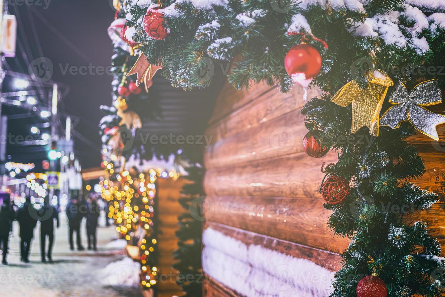 Kerstmis of nieuw jaar markt in een Europa met huizen versierd met speelgoed- ballen en slingers Bij nacht. wijnoogst film stijlvol. foto