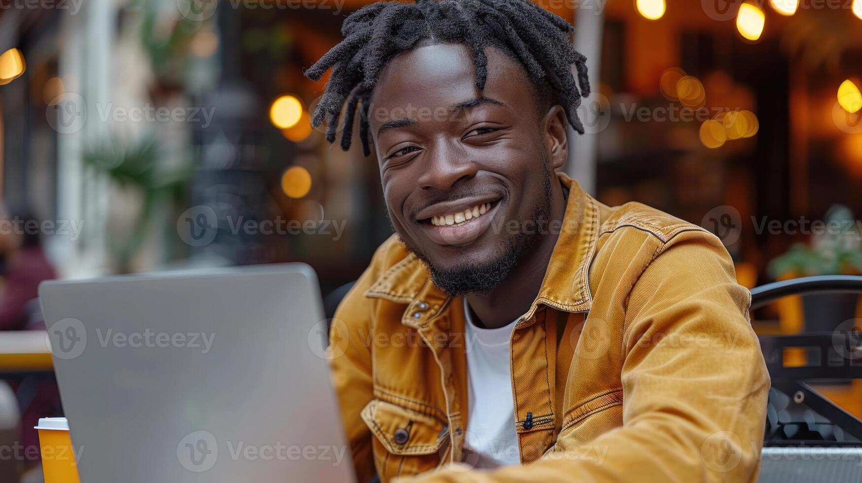 een Mens zittend in voorkant van een laptop computer, gefocust Aan zijn werk foto