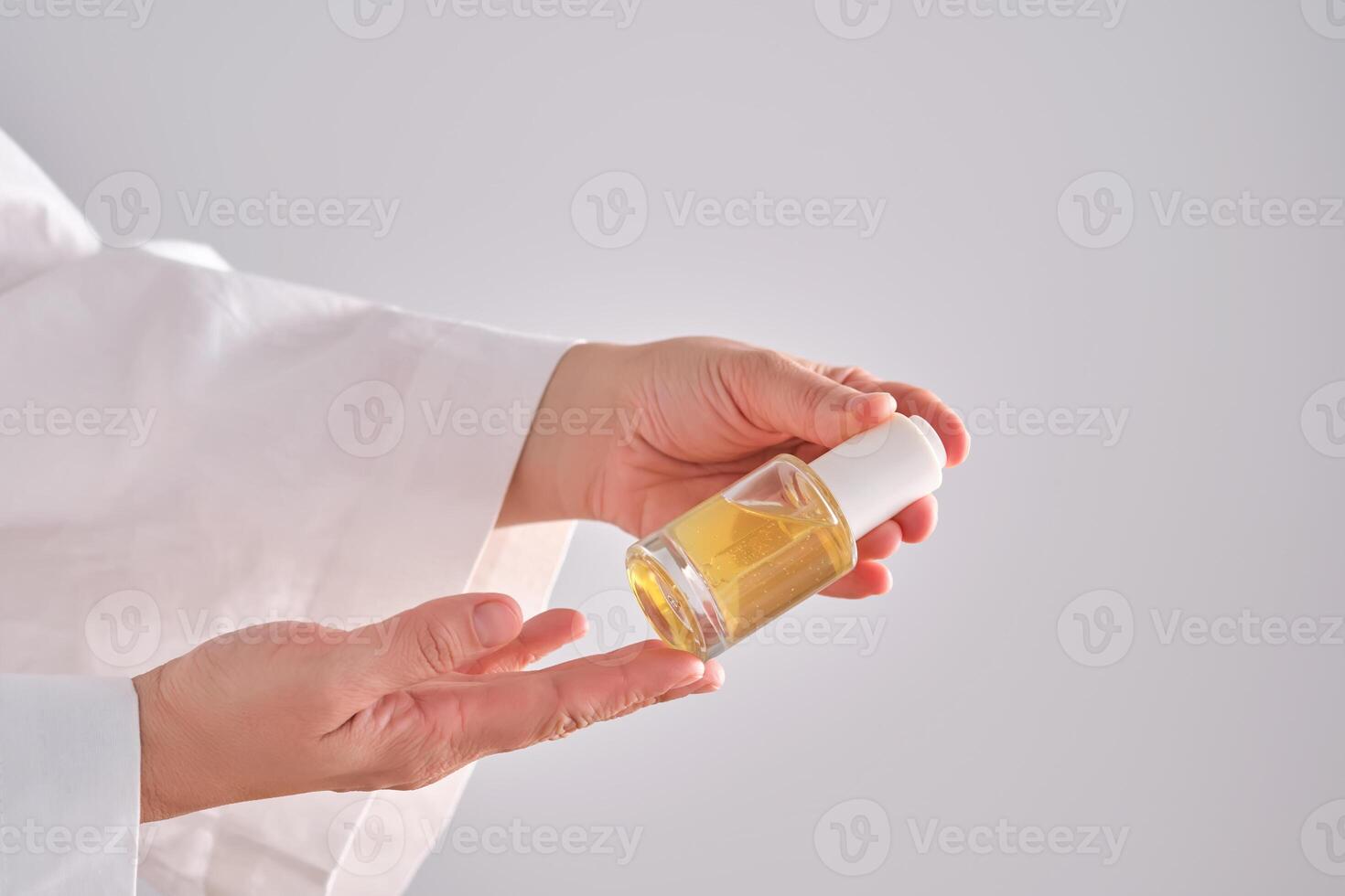 blauw serum met pipet in een dames handen in een gewaad. foto