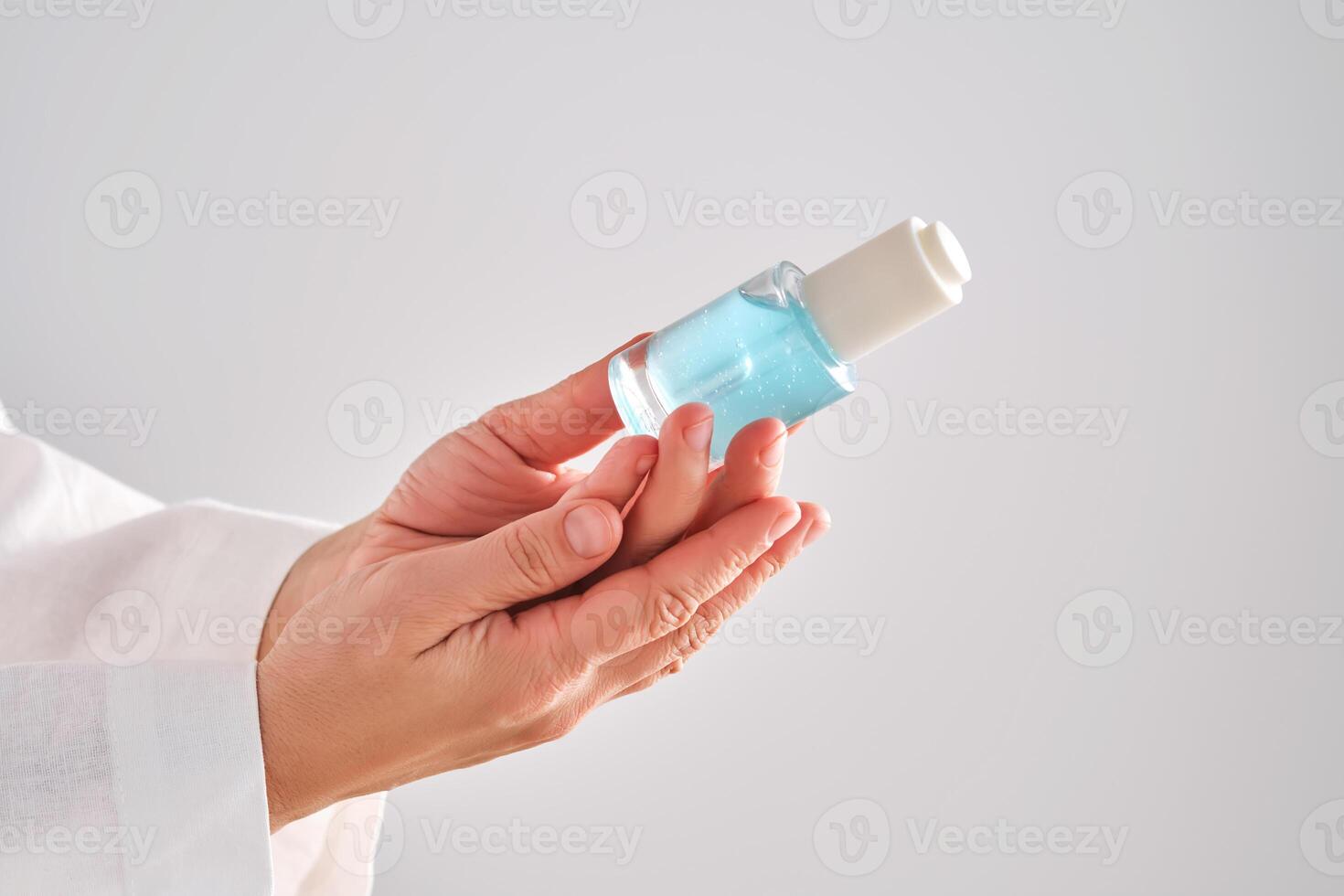 blauw serum met pipet in een dames handen in een gewaad. foto