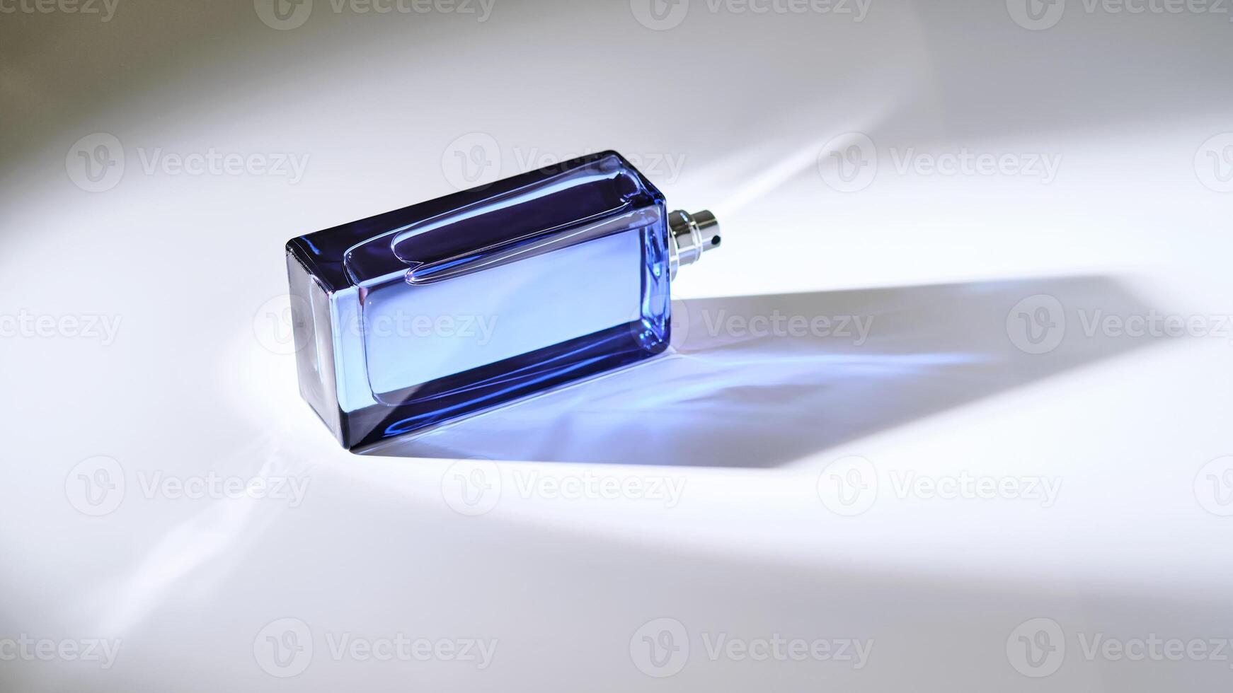 parfum verstuiven in een blauw fles Aan een wit achtergrond. foto