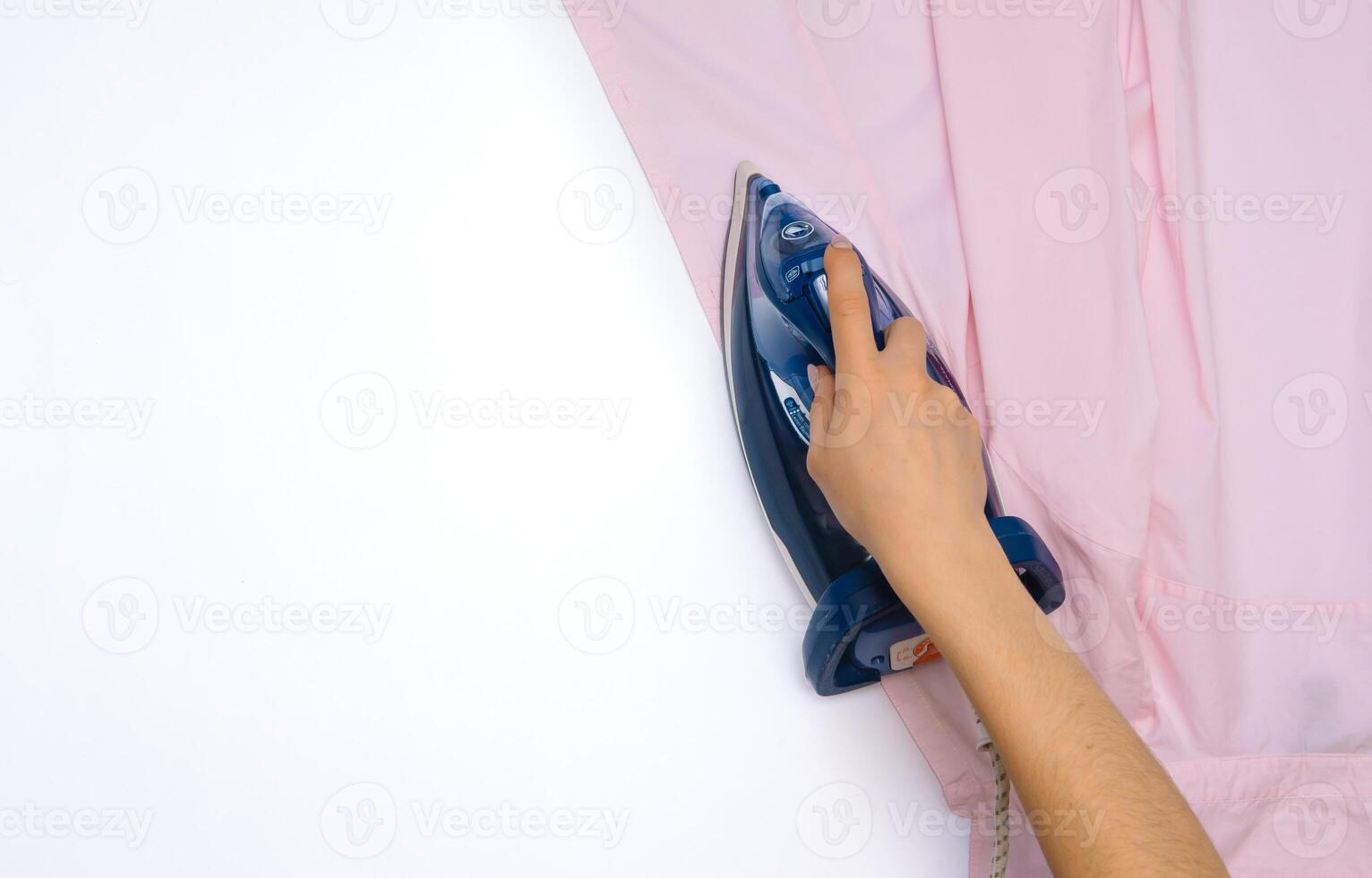 vrouw hand- strijken kleren top visie geïsoleerd Aan wit achtergrond. jong vrouw met ijzer strijken man's overhemd gezien van bovenstaand gedurende huiswerk. blauw ijzer Aan wit tafel foto