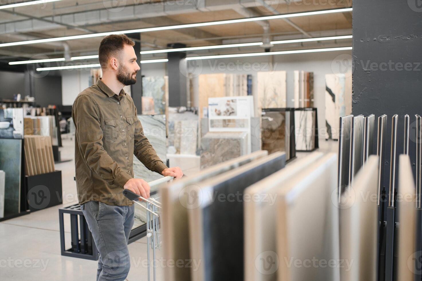 zelfverzekerd mannetje klant plukken uit muur tegel materialen voor badkamer in hardware op te slaan foto