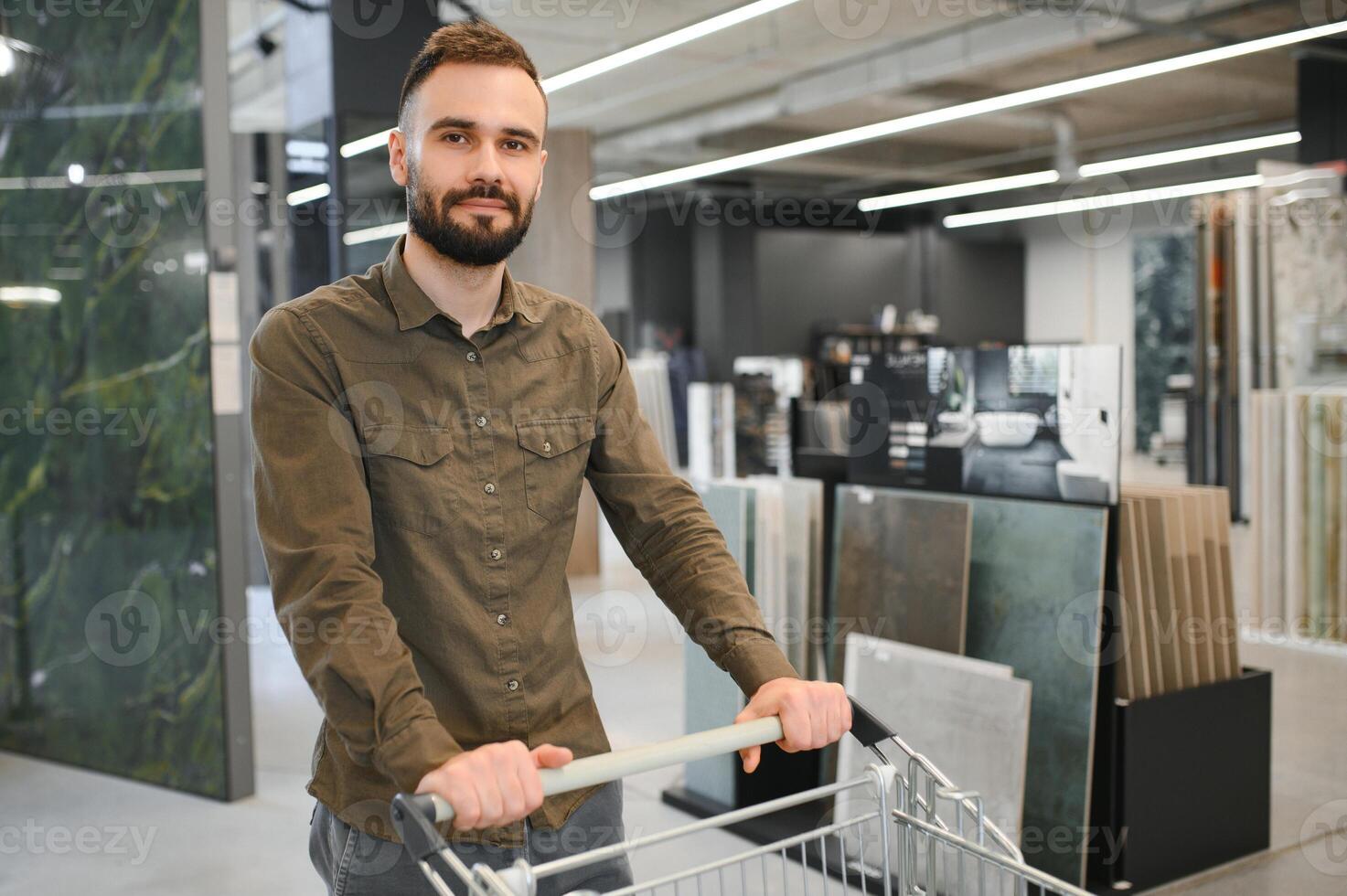 zelfverzekerd mannetje klant plukken uit muur tegel materialen voor badkamer in hardware op te slaan foto