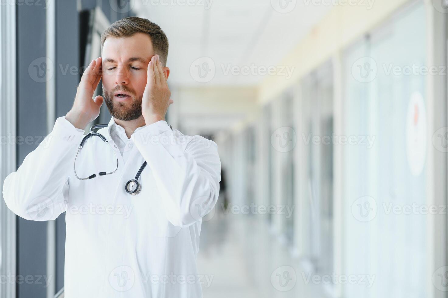 verdrietig dokter staand in ziekenhuis gang foto