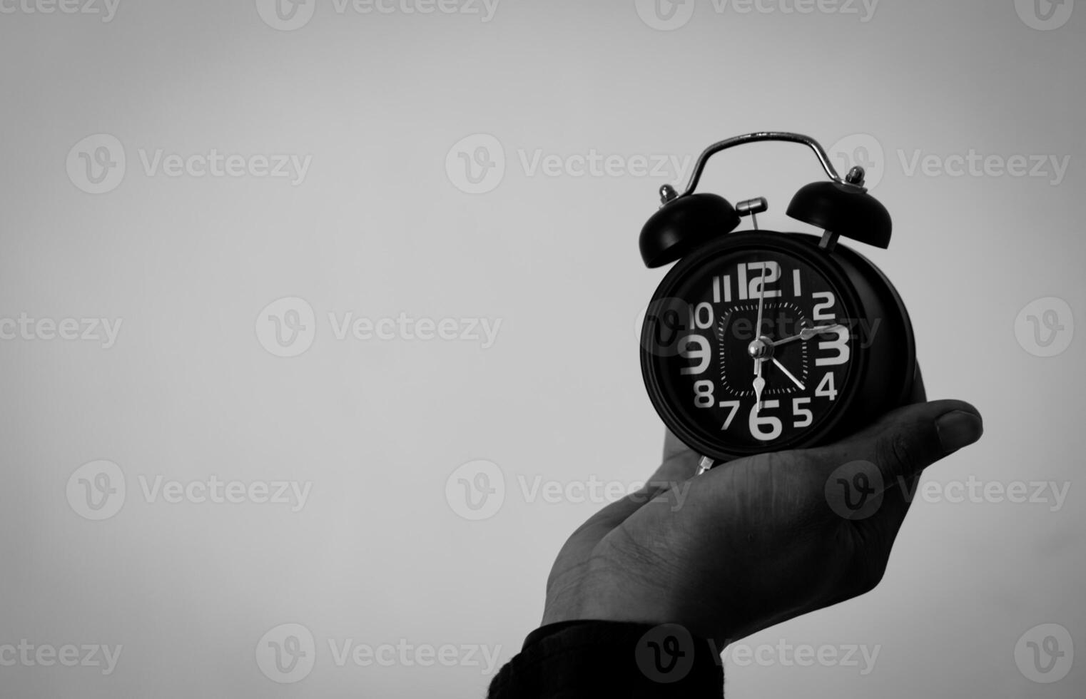 tijd beheer concept. Mens handen Holding zwart retro alarm klok. tijd naar wakker worden omhoog voor de ochtend- routine- foto