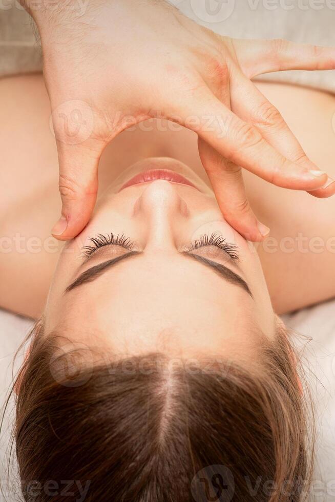 gezicht massage met vingers van een masseur. vrouw gelaats huid zorg Bij een schoonheid spa salon. foto