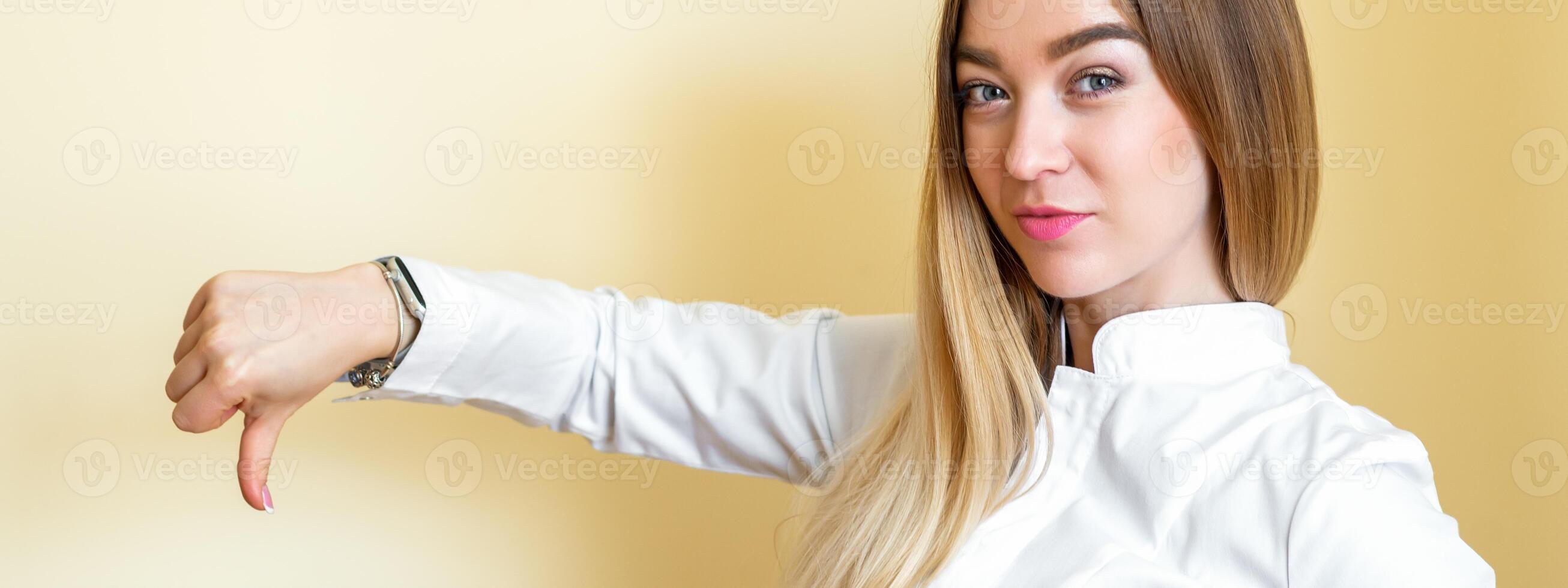 een vrouw tonen afkeer. jong mooi zakenvrouw vervelend een wit overhemd met duim naar beneden geïsoleerd over- een geel achtergrond. foto