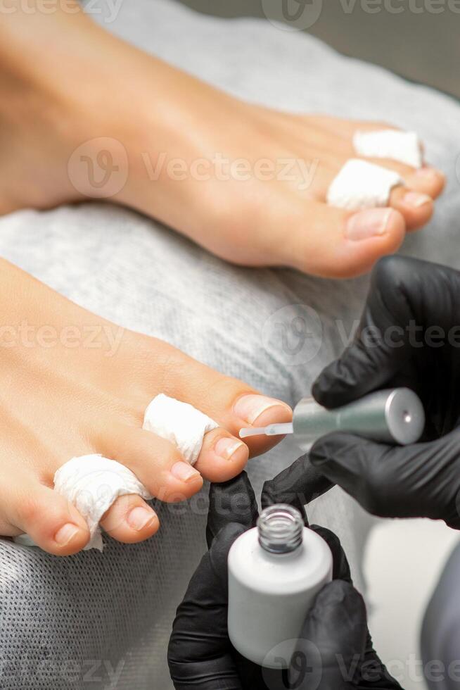 pedicure toepassen transparant vernis naar de vrouw teennagels in een schoonheid salon. foto