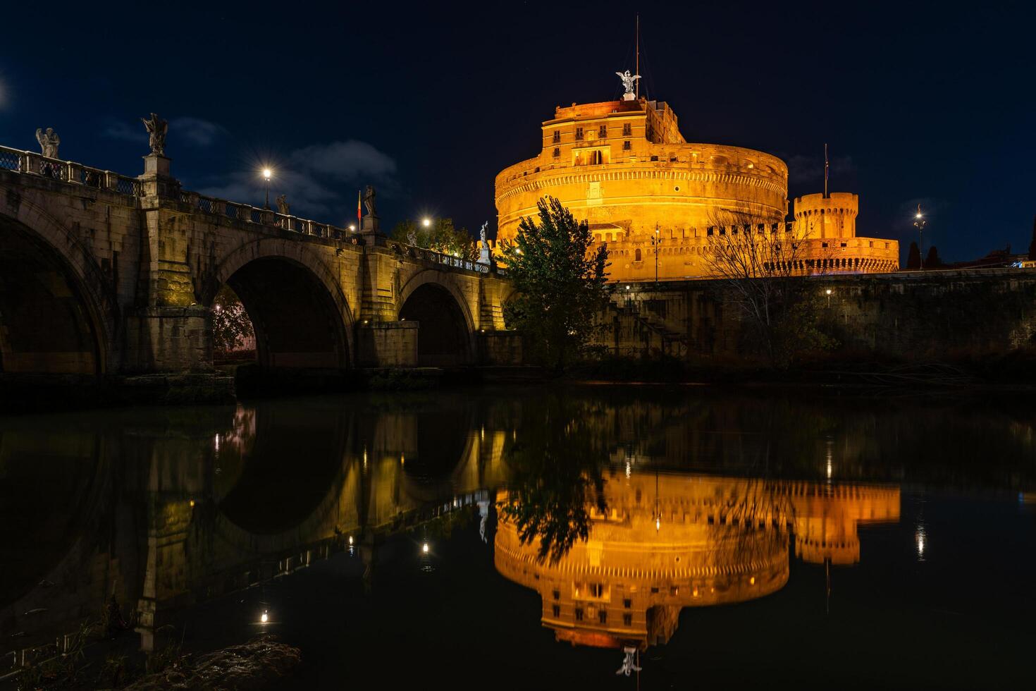 nacht visie van de castel sant'angelo vesting en de sant'angelo brug weerspiegeld in de tiber rivier- foto