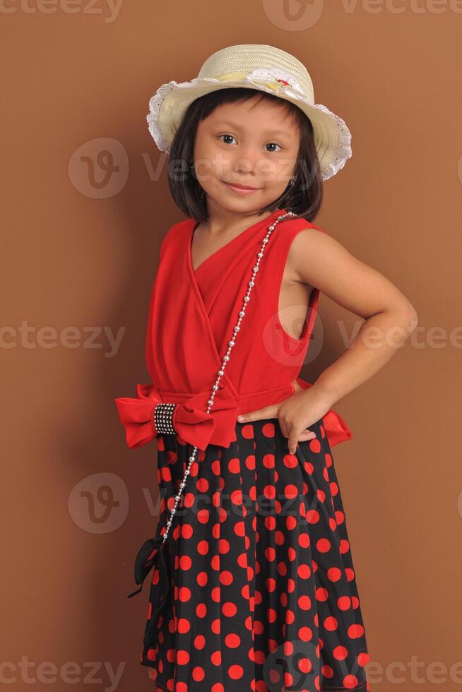 een Indonesisch weinig meisje vervelend modieus jurk met modellering houding. foto