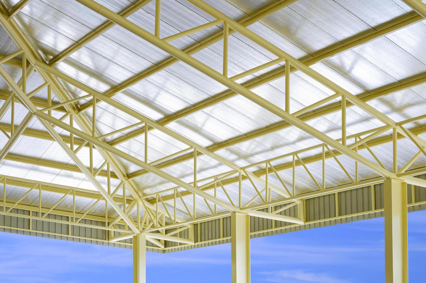 laag hoek en perspectief kant visie van geel metaal gebouw dak structuur met warmte isolaties in bouw plaats Oppervlakte met blauw lucht achtergrond foto