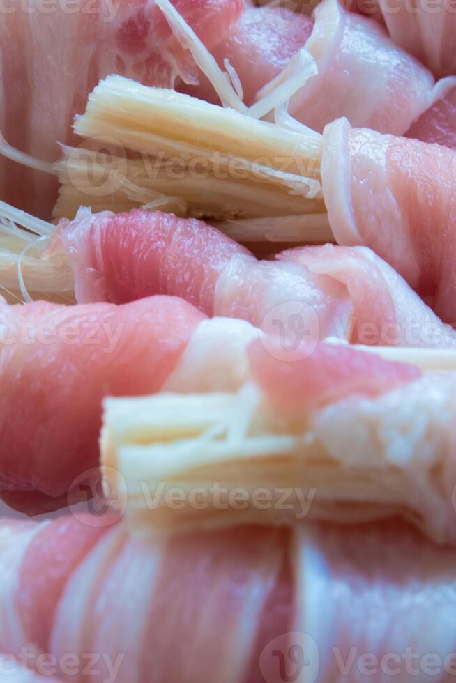 naald- paddestoel in de rollen van dun gesneden varkensvlees bereiden naar koken foto