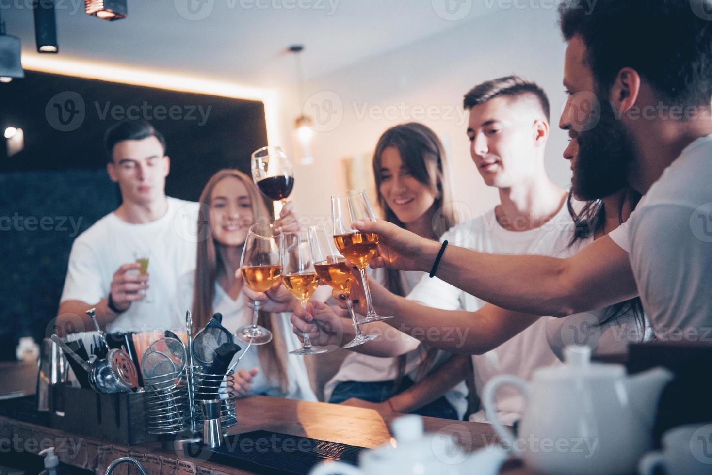 vrije tijd en communicatie concept. groep gelukkige lachende vrienden genieten van drankjes en praten in de bar of pub foto