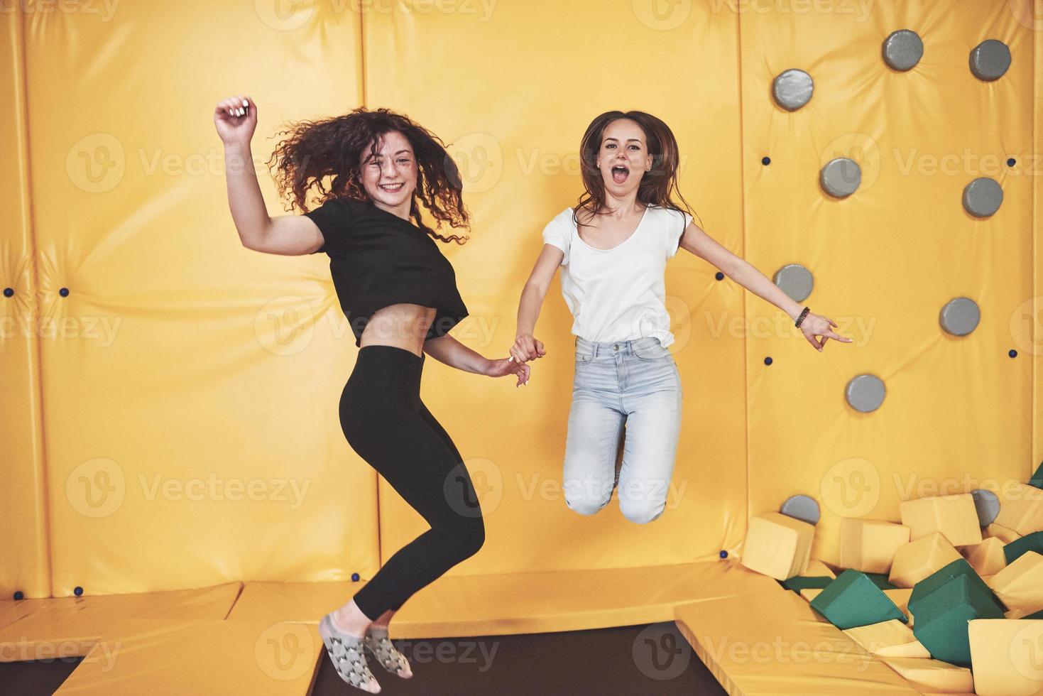 het bedrijf is een jonge vrouw die zich amuseert met zachte blokken op een kinderspeelplaats in een trampolinecentrum. foto