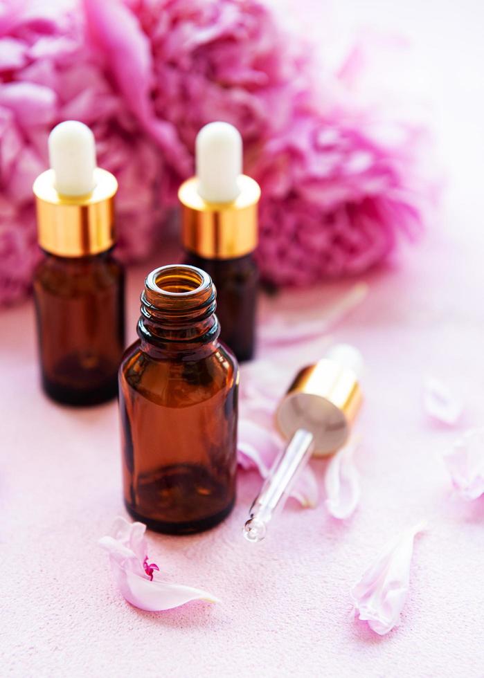 essentiële oliën voor aromatherapie en roze pioenrozen foto