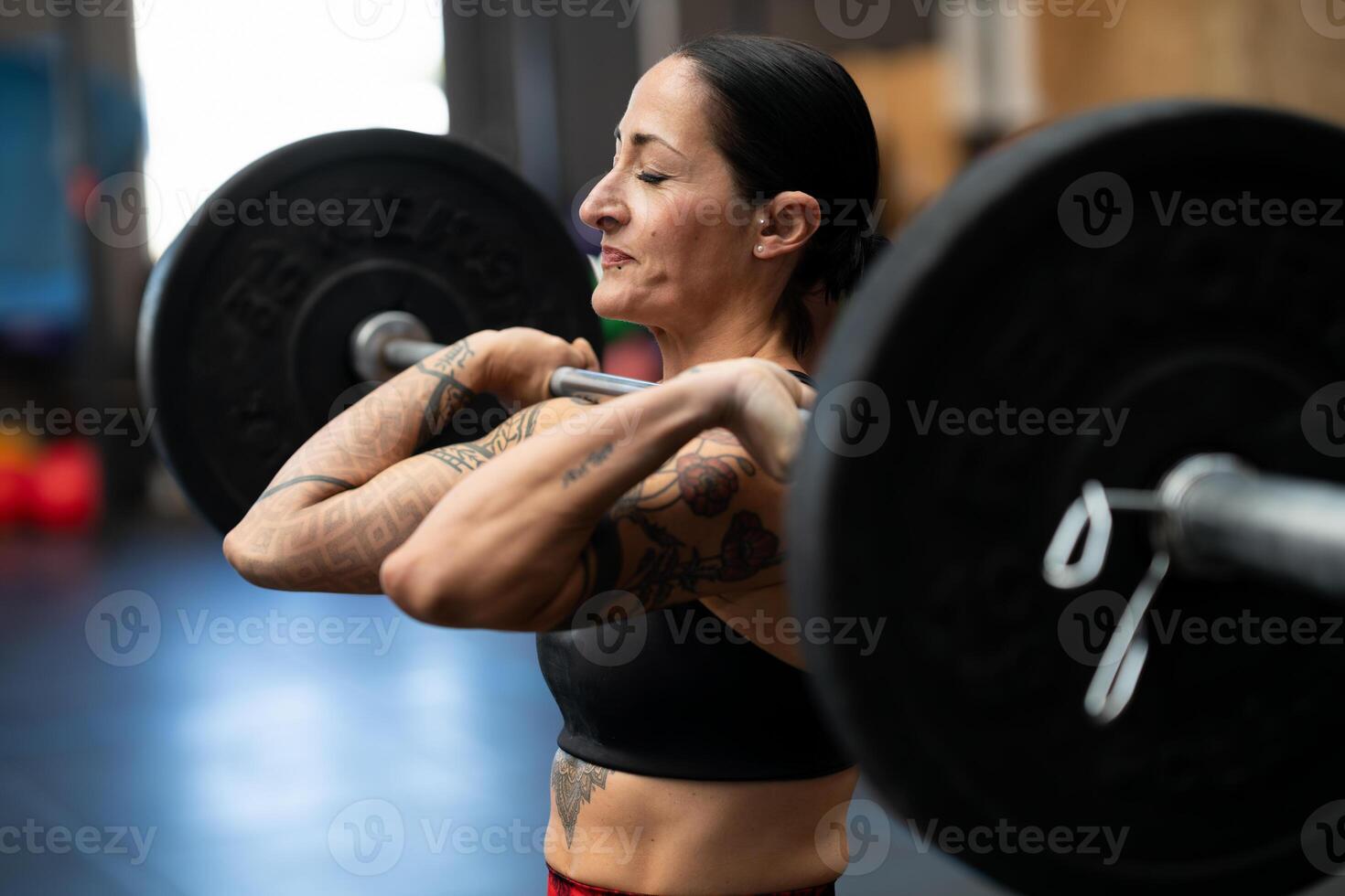 sportief sterk vrouw aan het doen een inspanning naar optillen gewichten foto