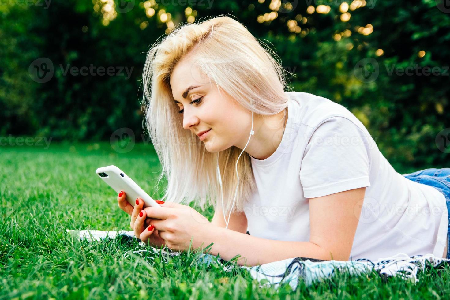 vrouw in koptelefoon en smartphone in handen luistert naar muziek foto