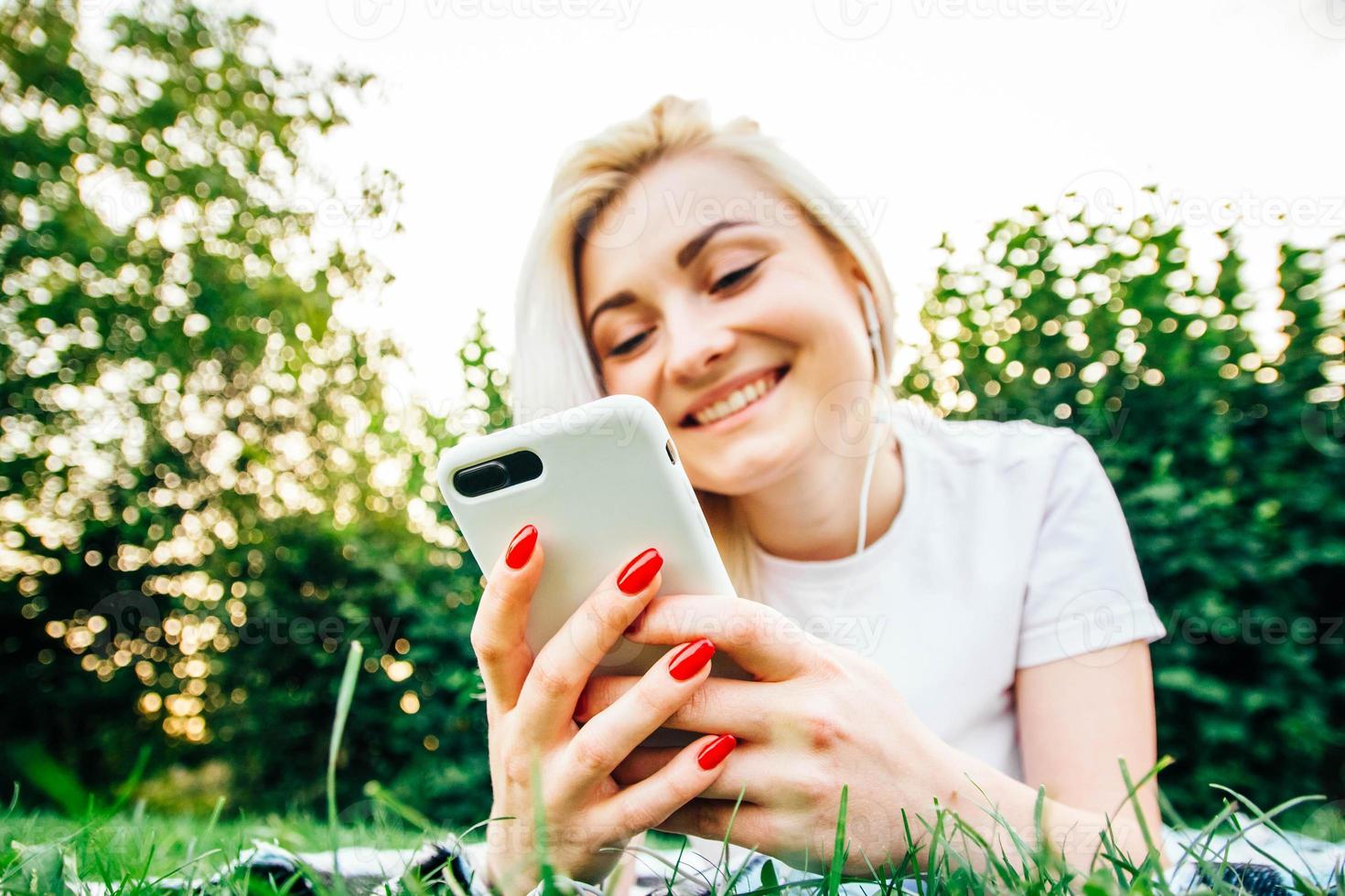 vrouw in koptelefoon en smartphone in handen luistert naar muziek foto