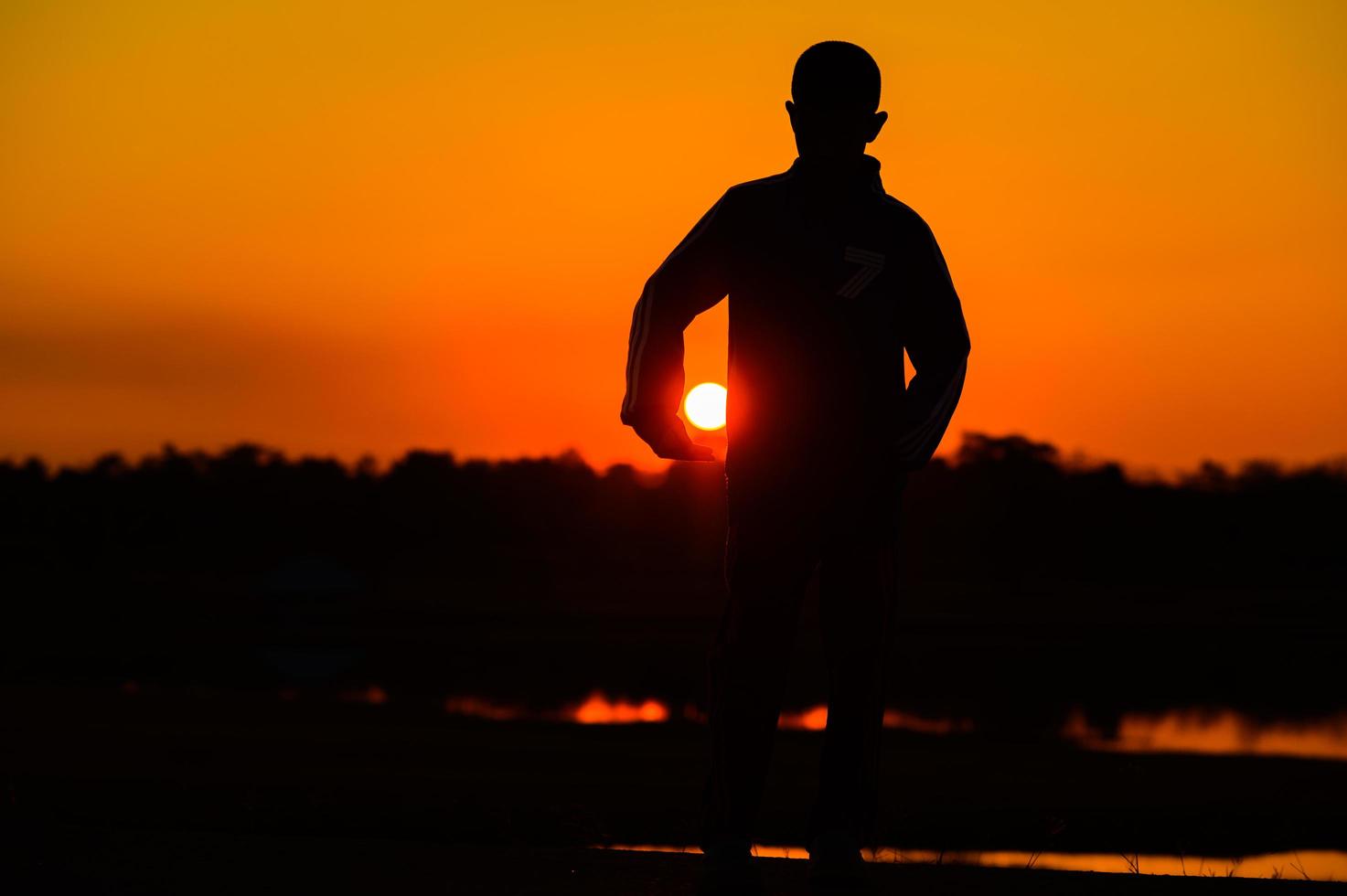 kindsilhouet speelplezier met veel vrienden en spelen tegen de zonsondergang foto