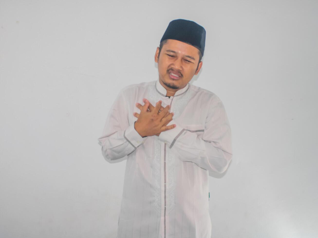 Moslim volwassen Aziatisch Mens aanraken zijn borst met pijn uitdrukking foto