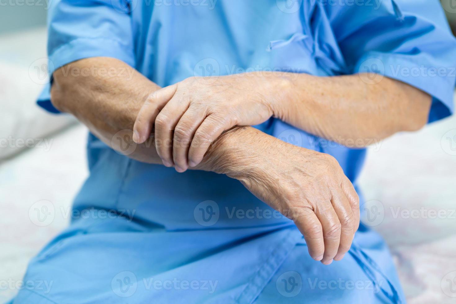 Aziatische senior of oudere oude dame vrouw patiënt voelt pijn aan arm en hand op bed in verpleegafdeling, gezond sterk medisch concept. foto