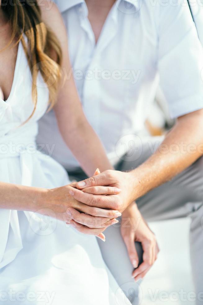 de bruid en bruidegom houden teder elkaars hand vast liefde foto