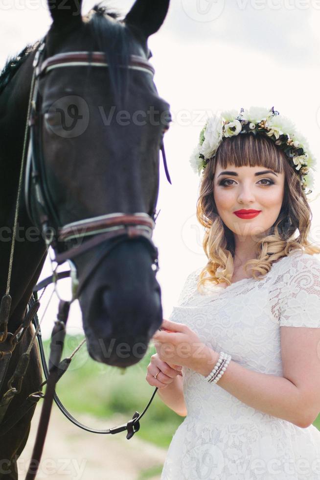 meisje met rode lippen bij een zwart paard foto