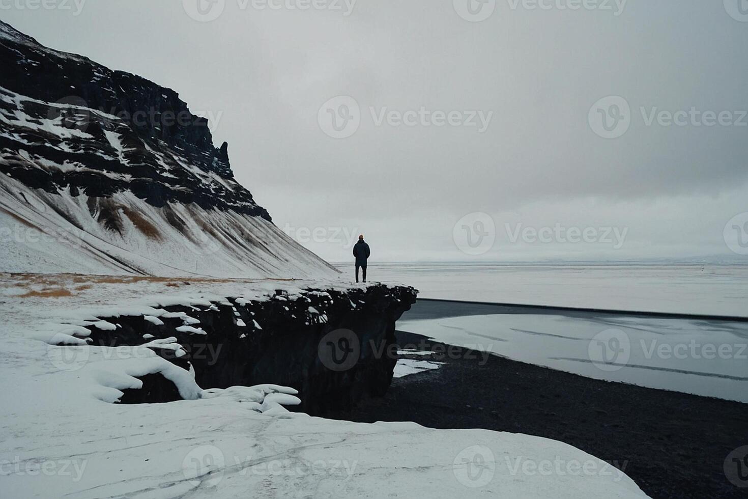 een persoon staand Aan een klif met uitzicht een lichaam van water foto